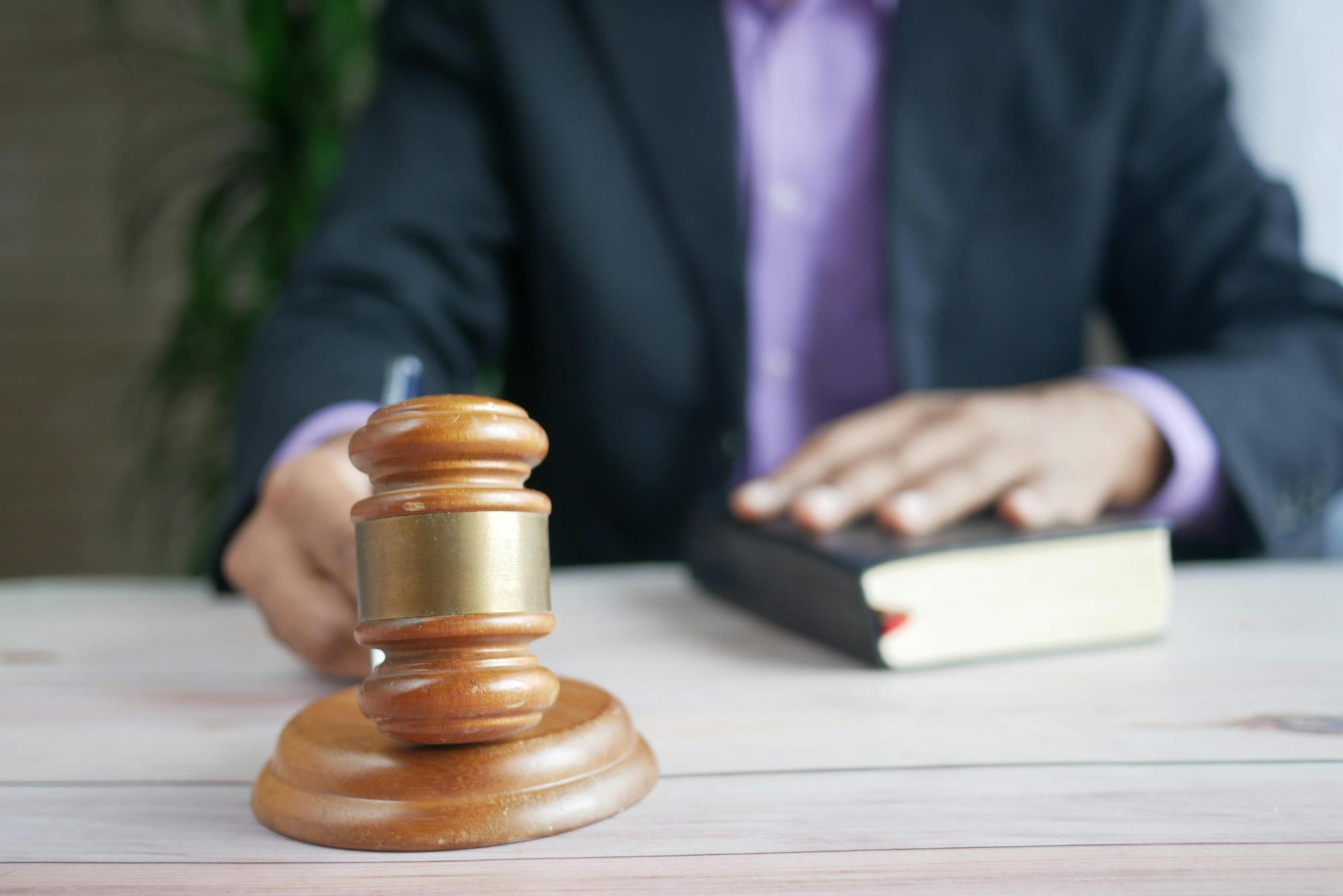 Man with purple shirt holding gavel